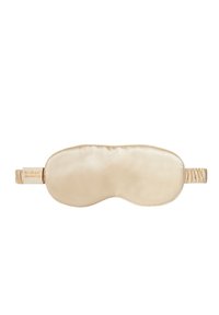 Jedwabna opaska na oczy w miękkim beżowym kolorze o gładkiej fakturze. Posiada marszczony elastyczny pasek oraz metkę wskazującą 100% jedwab morwowy.