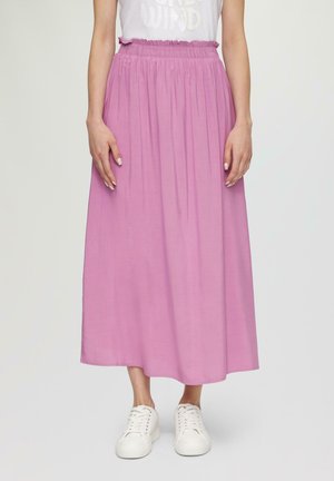 Różowa spódnica do kostek z marszczonym, elastycznym pasem i gładką, lejącą się fakturą, w połączeniu z białymi trampkami.