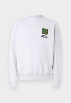 Grå hettegenser laget av mykt stoff. Har rund hals, ribbestrikkede mansjetter og en liten grafisk logo i grønn og svart på brystet.