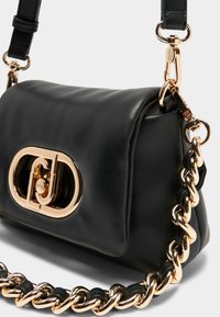 Sort læder håndtaske med en logo lukning i guldtoner, en glat overflade og en kædestropp med læderdetaljer.