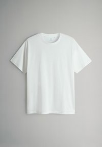 Gładki biały T-shirt z krótkim rękawem i okrągłym dekoltem, prezentowany na neutralnym szarym tle.