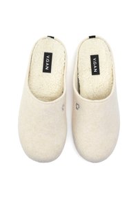 Beige vegan slippers with a soft, textured upper and a plush, off-white lining. Features a small logo tag on each slipper.