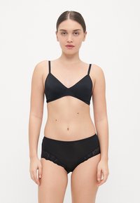 Black bra with a smooth finish and adjustable straps, paired with matching black panties featuring lace accents on the sides.