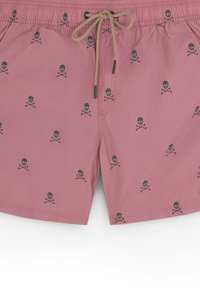 Pantaloni de baie roz dintr-un material ușor, cu un model repetat de cranii și oase încrucișate negre, având un cordon la talie pentru ajustare.