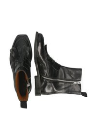 Botas de cuero negras con punta afilada, cierre de cremallera en el lateral, acentos decorativos trenzados en la parte frontal y un tacón bajo y apilado.