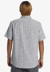 Kurzärmeliges Button-up Hemd aus hellgrauem Stoff mit vertikalen, mehrfarbigen Streifen. Verfügt über einen klassischen Kragen und eine Riegelverarbeitung am Rücken.