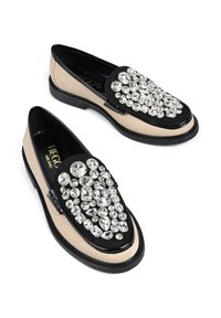 Czarno-beżowe mokasyny o błyszczącej powierzchni, ozdobione dużymi, przezroczystymi kryształami na cholewce, z okrągłym noskiem i niskim obcasem.