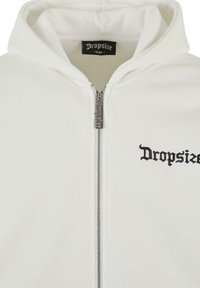 Hoodie blanc zippé avec capuche à cordon. Présente un logo "Dropsize" brodé en noir sur la poche gauche et une fermeture éclair métallique. Tissu au toucher doux.