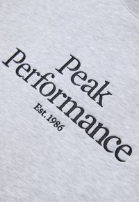 Grå bomulds sweatshirt med sort broderet tekst: "Peak Performance" og "Est. 1986." Enkel design, glat tekstur, rund hals.