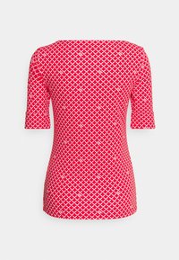 Czerwona koszulka z krótkim rękawem, ozdobiona białym wzorem w diamenty. Materiał wydaje się gładki, ma dopasowaną sylwetkę i okrągły dekolt.