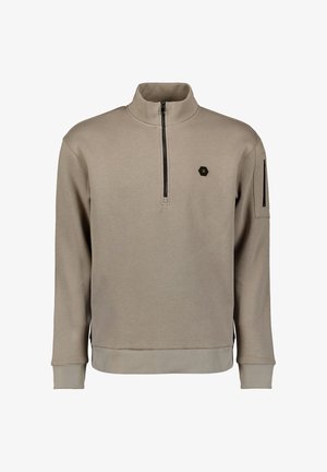 Beige sweatvest met ritssluiting en hoge kraag, zwarte accenten op de mouwen, geribbelde manchetten en een klein zeshoekig logo op de borst. Zachte textuur.