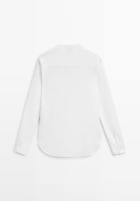 Wit shirt met lange mouwen en knoopmanchetten, gezien vanaf de achterkant, met een rechte inzet en afgeronde zoom.