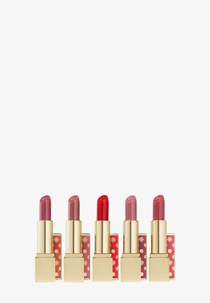 Five Estée Lauder lipsticks in varying shades of pink and red with gold and festive red-gold patterned cases.