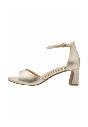Sandale à talon métallique doré avec bout ouvert, bride de cheville réglable et talon bloc. Texture lisse, design minimaliste.