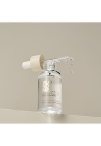 Heldere glazen fles met een witte druppelaar en beige accent. Bevat lichte olie met het label "BLONDME BONDINFINITY DEEP REPAIR OIL," 50 ml.