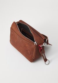 Bolso de cuero marrón con diseño grabado de flores, cremallera plateada, interior negro y un llavero con acento rojo. Forma rectangular redondeada.