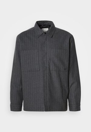 Camisa de botones gris oscuro hecha de un tejido texturizado con rayas verticales blancas, con dos bolsillos frontales y un diseño de cuello clásico.