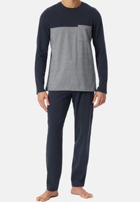 Set di pigiama a due pezzi blu navy e grigio, composto da una maglia a maniche lunghe con un pannello e una tasca grigia sul petto, abbinata a pantaloni navy coordinati.