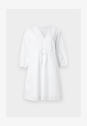 Valge põlvpikkusega kleit V-kaelusega, pikkade volangiliste varrukatega ja kogutud vööpaelaga ühtlasel taustal.