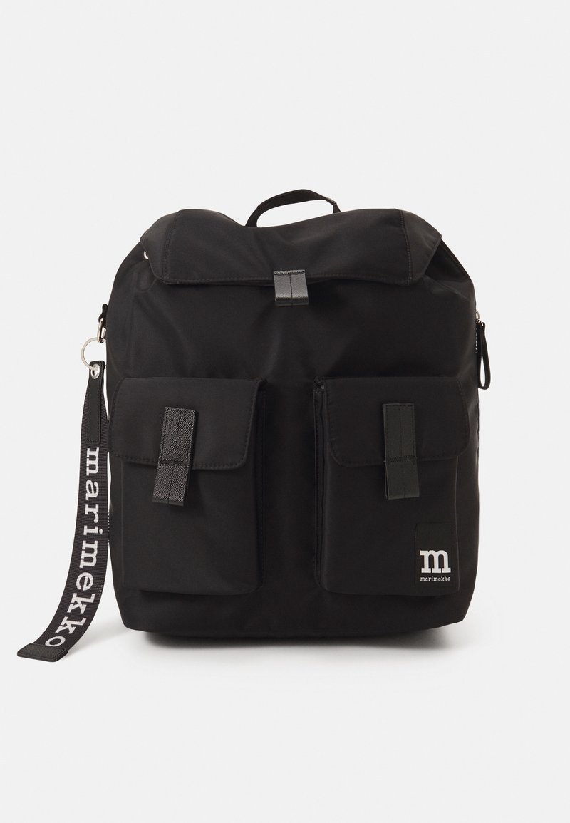 Sac à dos noir avec rabat supérieur, deux poches avant avec fermetures et une sangle de marque « marimekko » suspendue sur le côté.
