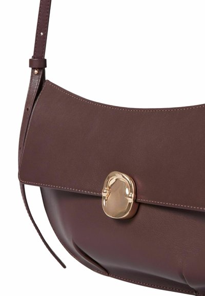 Borsa a spalla in pelle marrone con una chiusura in tono oro, texture liscia, forma curvata e un delicato dettaglio di cucitura sul pattina.