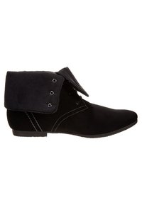 Botte chelsea en suède noir avec revers replié, devant à lacets et coutures blanches visibles sur le côté.