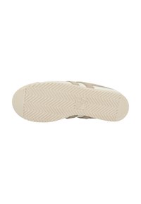 Suola di sneaker in suede beige con suola in gomma crema testurizzata, caratterizzata da un motivo a spina di pesce e un logo del marchio sul lato.