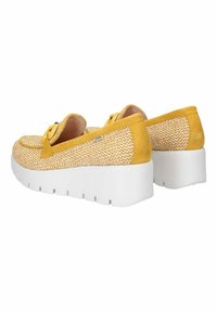 Scarpe slip-on gialle intrecciate con una parte superiore testurizzata, un accento in morbido suede e una robusta suola piattaforma bianca. Presentano un dettagli decorativo a forma di fiocco.