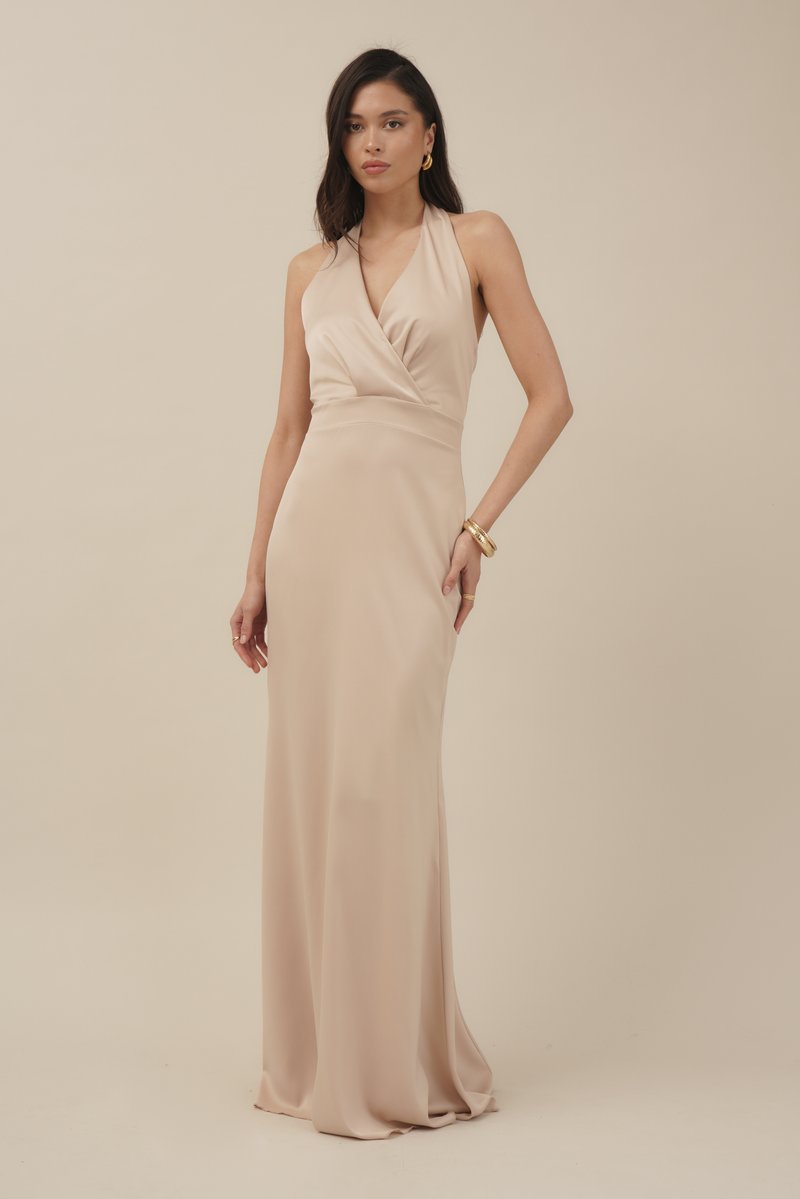 Vestido nude de cuello halter con un cuerpo ajustado y falda fluida. Confeccionado en una tela suave, presenta detalles drapeados en el escote.
