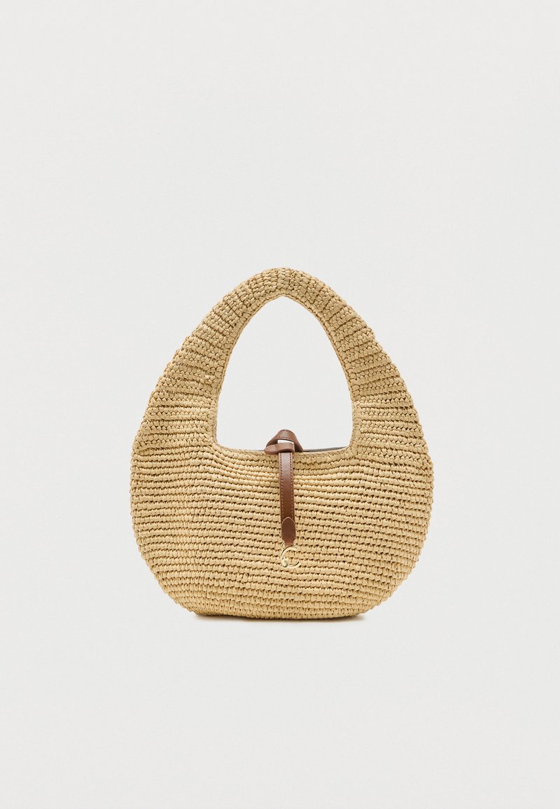 Πλεγμένη τσάντα από ψάθα με στρογγυλεμένο σχήμα, ενσωματωμένη λαβή και κλείσιμο με καφέ δερμάτινο λουράκι σε ανοιχτό φόντο.