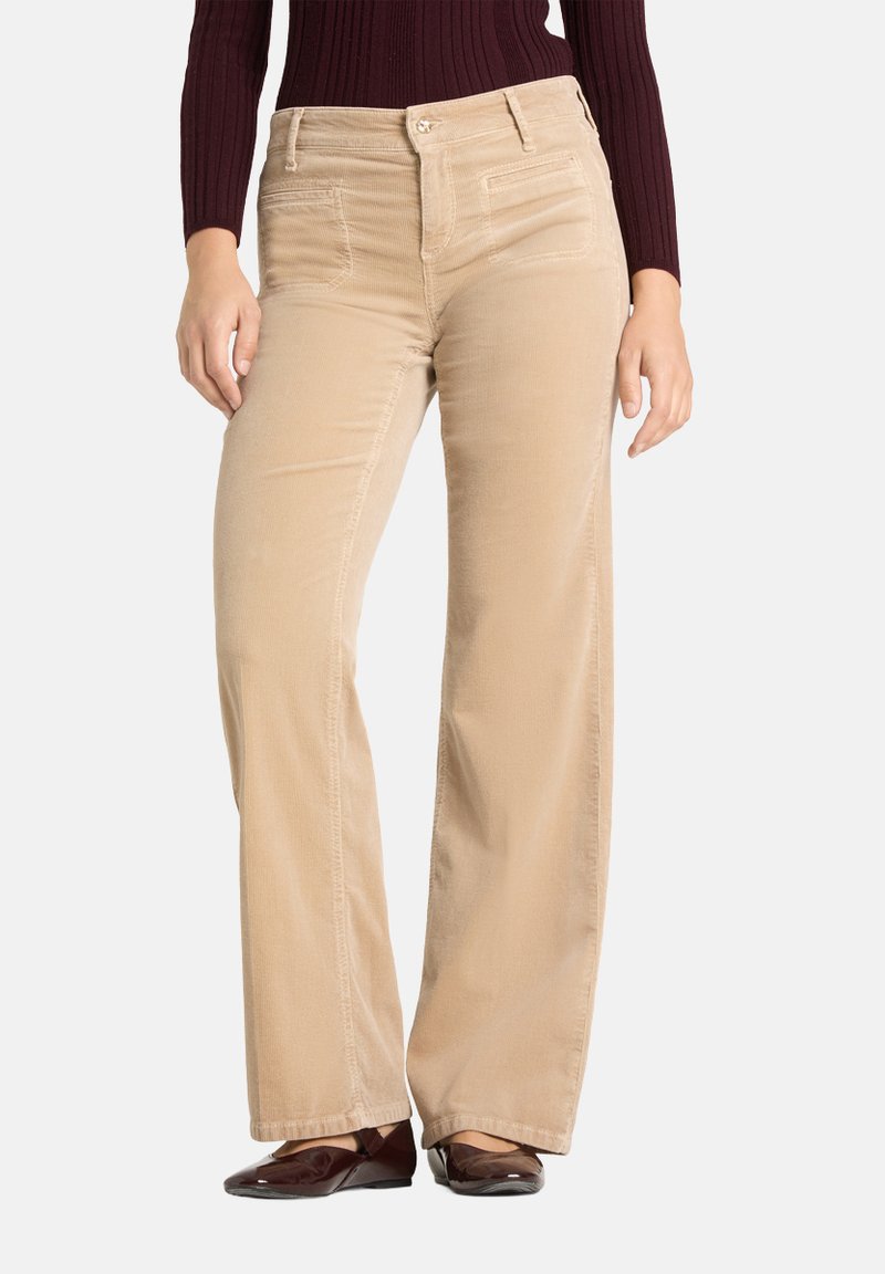 Pantalon en velours côtelé beige avec une coupe droite, doté de poches avant et d'une fermeture à bouton. Texture douce avec des nervures verticales.