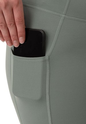 Leggings atletici a vita alta in verde tenue, con una tasca laterale progettata per uno smartphone, realizzati in tessuto morbido e elasticizzato.