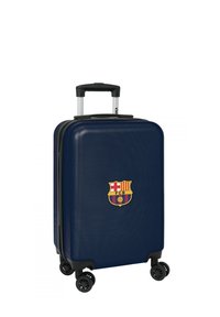 Valigia rigida blu navy con logo del FC Barcelona, manico telescopico, quattro ruote girevoli nere e superficie testurizzata per una maggiore durata.