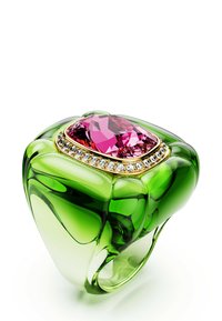 Groene doorschijnende ring met een grote roze edelsteen in het midden, omringd door kleine heldere kristallen op een witte achtergrond.