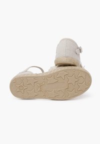 Sandale en tissu blanc avec une tige texturée, une bride réglable et une semelle intermédiaire en jute. Semelle extérieure en caoutchouc à motif étoilé pour une bonne traction.