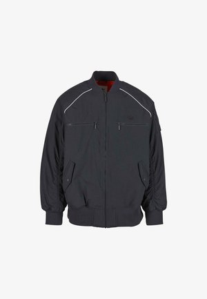 Čierna bomber bunda s rebrovanými manžetami a golierom, dvoma zipsovými vreckami na hrudi, bočnými vreckami na gombíky a nenápadným logom na ľavej strane hrudníka.