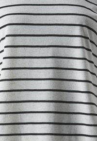 Helles graues T-Shirt mit horizontalen schwarzen Streifen. Der Stoff wirkt weich mit einer subtilen Textur und leichten Unregelmäßigkeiten.