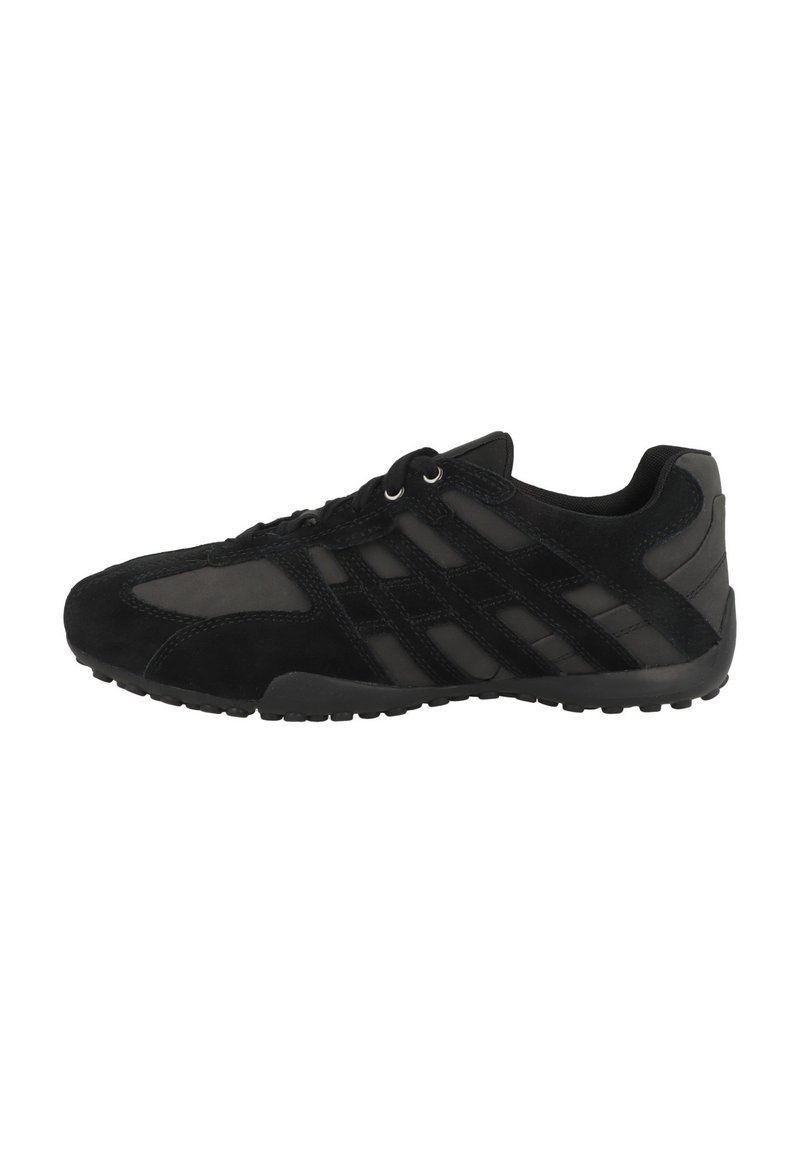 Scarpa sportiva nera con tomaia in suede e mesh, design con lacci e suola in gomma testurizzata con accenti di pattern.