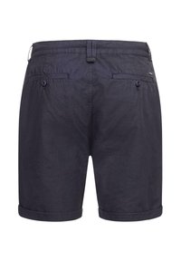 Marineblaue Shorts mit glatter Textur, umgeschlagenem Saum, zwei Gesäßtaschen mit Knöpfen und einem Logo-Detail nahe dem Bund.