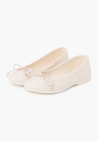 Ballerines beiges avec bout arrondi, détail en nœud et design minimaliste. Tige en tissu doux et semelle en caoutchouc plate pour un confort optimal.