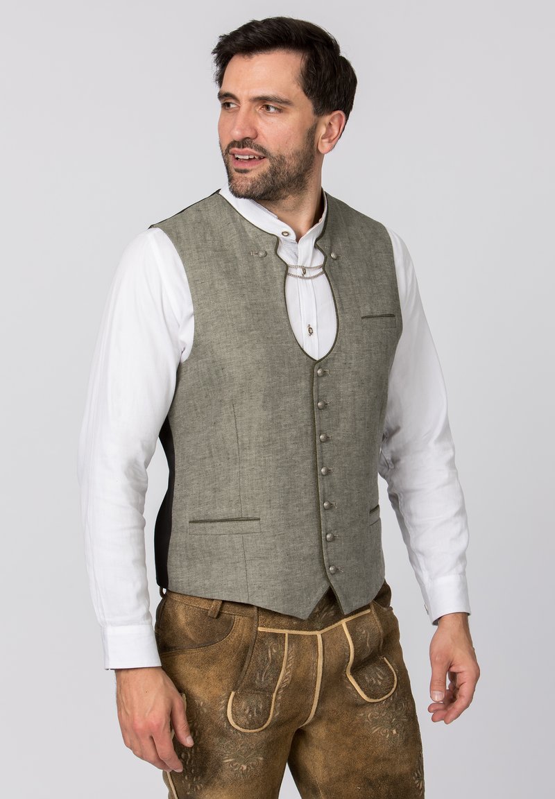 Grau leinenvest mit rundem Ausschnitt, Vorderknöpfen und zwei kleinen Taschen. Getragen über einem weißen Hemd mit traditionellem Design.