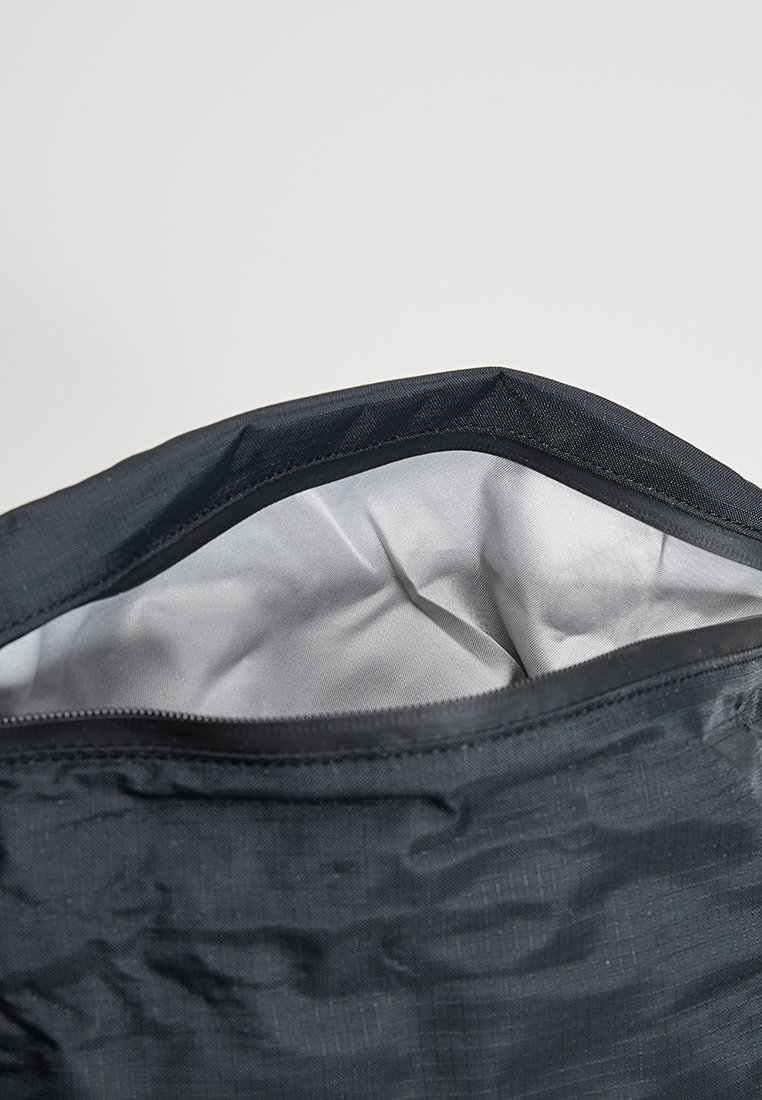 Schwarze Stofftasche mit Reißverschlussoberteil, ausgestattet mit einem glatten grauen Innenraum. Die Außenseite hat eine dezente Textur und ist leicht.