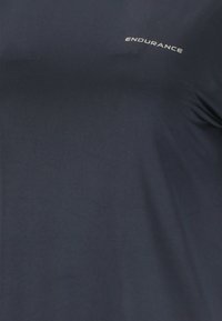 Donker marineblauwe stof met het woord "ENDURANCE" in het wit gedrukt, vlak bij de rechterbovenhoek.