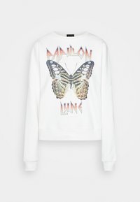 Bílý zkrácený sweatshirt s velkým grafikou motýla v odstínech hnědé, béžové a zelené, s textem "PAPILON LUNE" v tučné, ostré typografii.