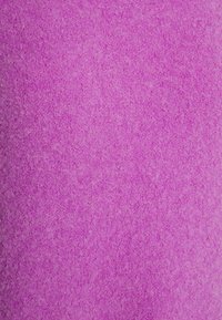 Tessuto magenta con una superficie morbida e pelosa, caratterizzato da un motivo uniforme e un colore ricco, ideale per progetti di artigianato o tappezzeria.