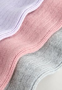 Tre strikkede stoffer i lilla, pink og grå, arrangeret i bølger. Hver har en tekstureret overflade og kontrasterende glatte kanter.