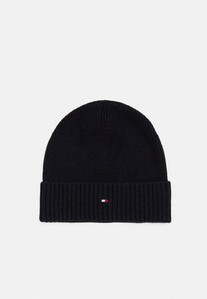 Bonnet en maille côtelée noire avec bord replié, présentant un petit patch logo rectangulaire rouge, blanc et bleu marine centré sur le bord.