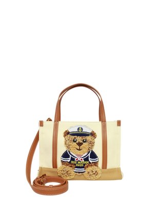 Borsa beige e marrone con manici in pelle marrone e un orsacchiotto ricamato sul davanti che indossa una divisa da marinaio blu navy con cappello.