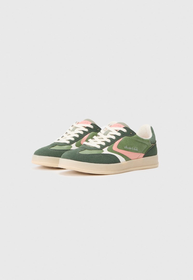 Groene sneaker met roze accenten, witte details, stoffen bovenwerk, platte veters, ronde neus en een beige rubberen zool.
