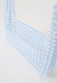 Gjennomsiktig blå perleveske med en strukturert design. Laget av plastperler, med en jevn tekstur og rektangulær form.